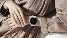 A person wearing a Samsung Galaxy Watch5 displaying a period prediction.