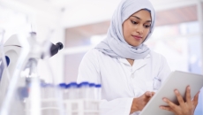 Scientist in a lab surrounded by microscopes