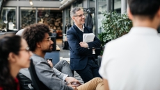 Numerous people sitting in a courtyard seated as though they are all looking at something Numerous people sitting in a courtyard seated as though they are all looking at something
