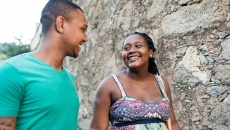 Two people walking together while looking at each other and smiling