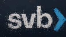 The Silicon Valley Bank (SVB) logo is seen through a rain covered window in front of the SVB headquarters.
