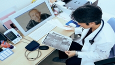 A doctor speaking with a patient using telehealth and looking at imaging results. A doctor speaking with a patient using telehealth and looking at imaging results.