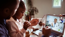 A father and a daughter doing a telehealth visit A father and a daughter doing a telehealth visit