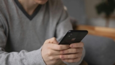 A person sitting in a couch using a smartphone A person sitting in a couch using a smartphone