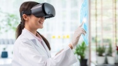 Healthcare provider wearing a virtual reality headset while touching a virtual screen