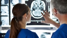 Two healthcare providers looking at a brain imaging scan