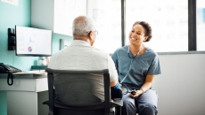 Healthcare provider sitting next to a patient in the clinical setting