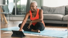 A woman takes an online exercise class on a tablet A woman takes an online exercise class on a tablet