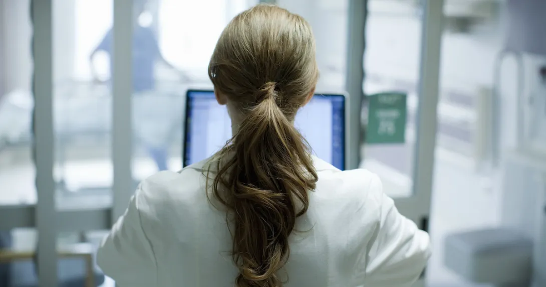 Person sitting at a computer with their back turned
Person sitting at a computer with their back turned
